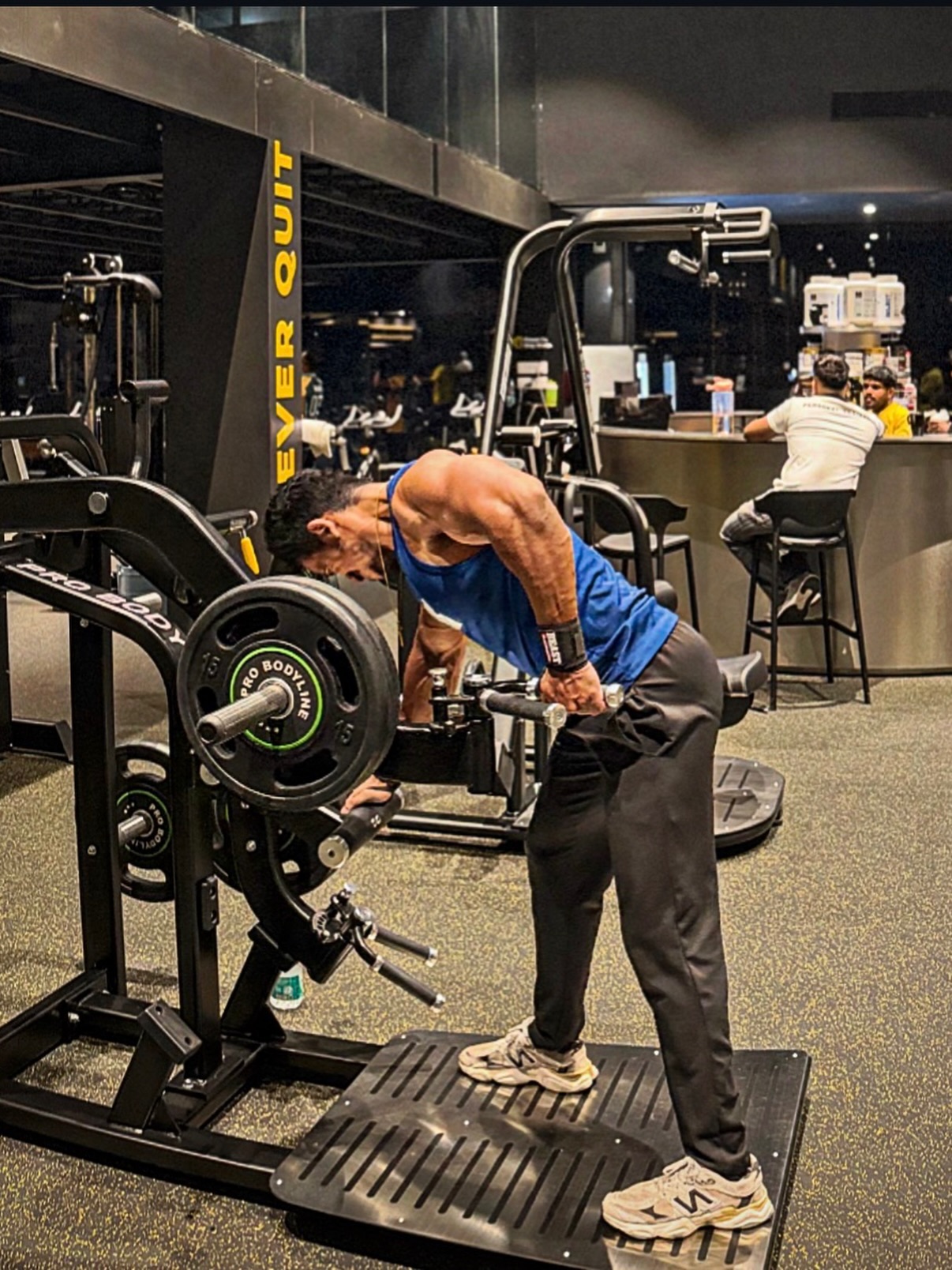 T-bar row training in front of NEVER QUIT wall